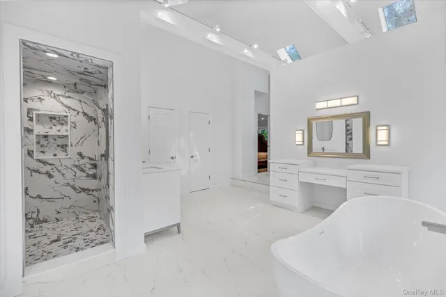 a large white kitchen with granite countertop a large window