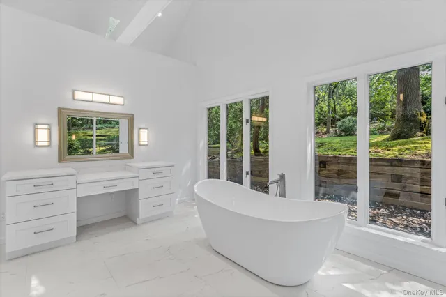 a bathroom with a tub sink and mirror