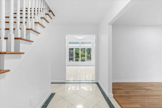 a view of an empty room with window and furniture