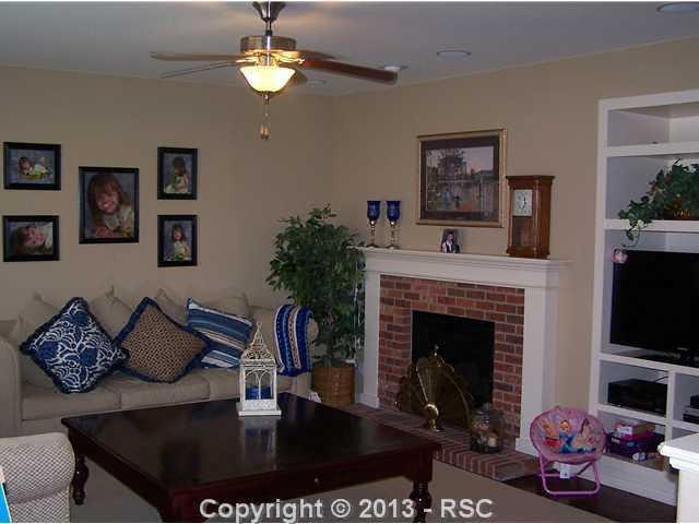 812 Spectrum Loop Colorado Springs, CO 80921 - Photo 4 of 17 Brick surrounded gas fireplace and custom built in entertainment center.
