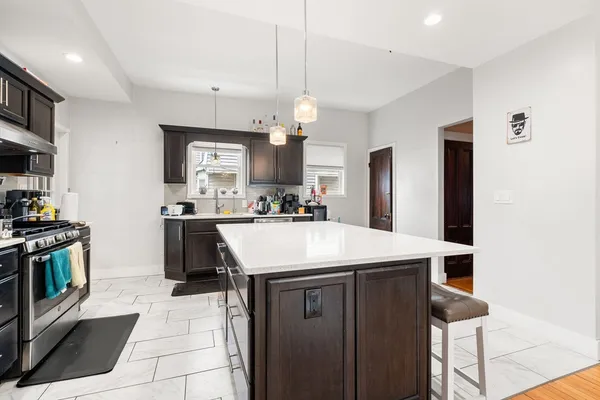 a kitchen with kitchen island a sink appliances and cabinets