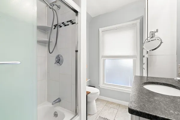 a bathroom with a granite countertop sink toilet and shower