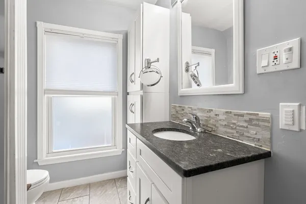 a bathroom with a granite countertop sink and a mirror