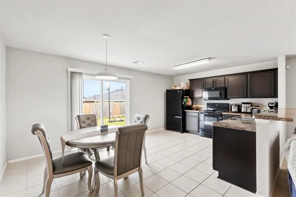 a view of a dining room with furniture a kitchen and chandelier