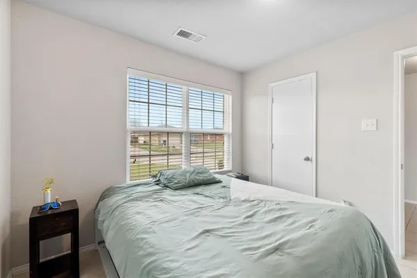 a bed sitting in a bedroom next to a window