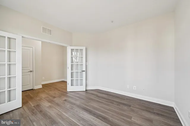 an empty room with wooden floor and a fireplace