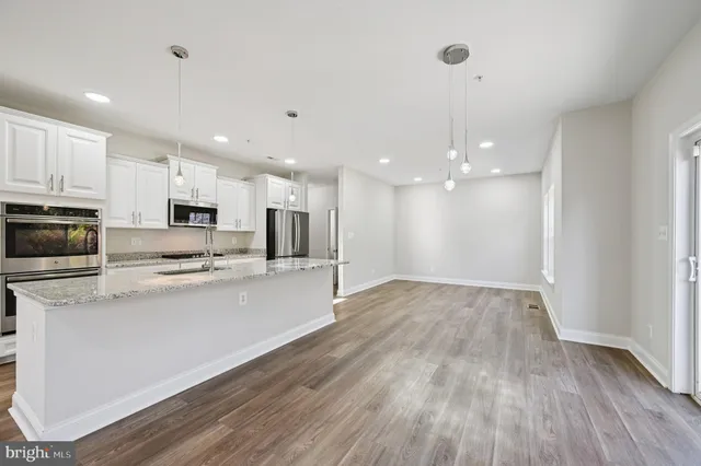 a kitchen with granite countertop white cabinets and stainless steel appliances
