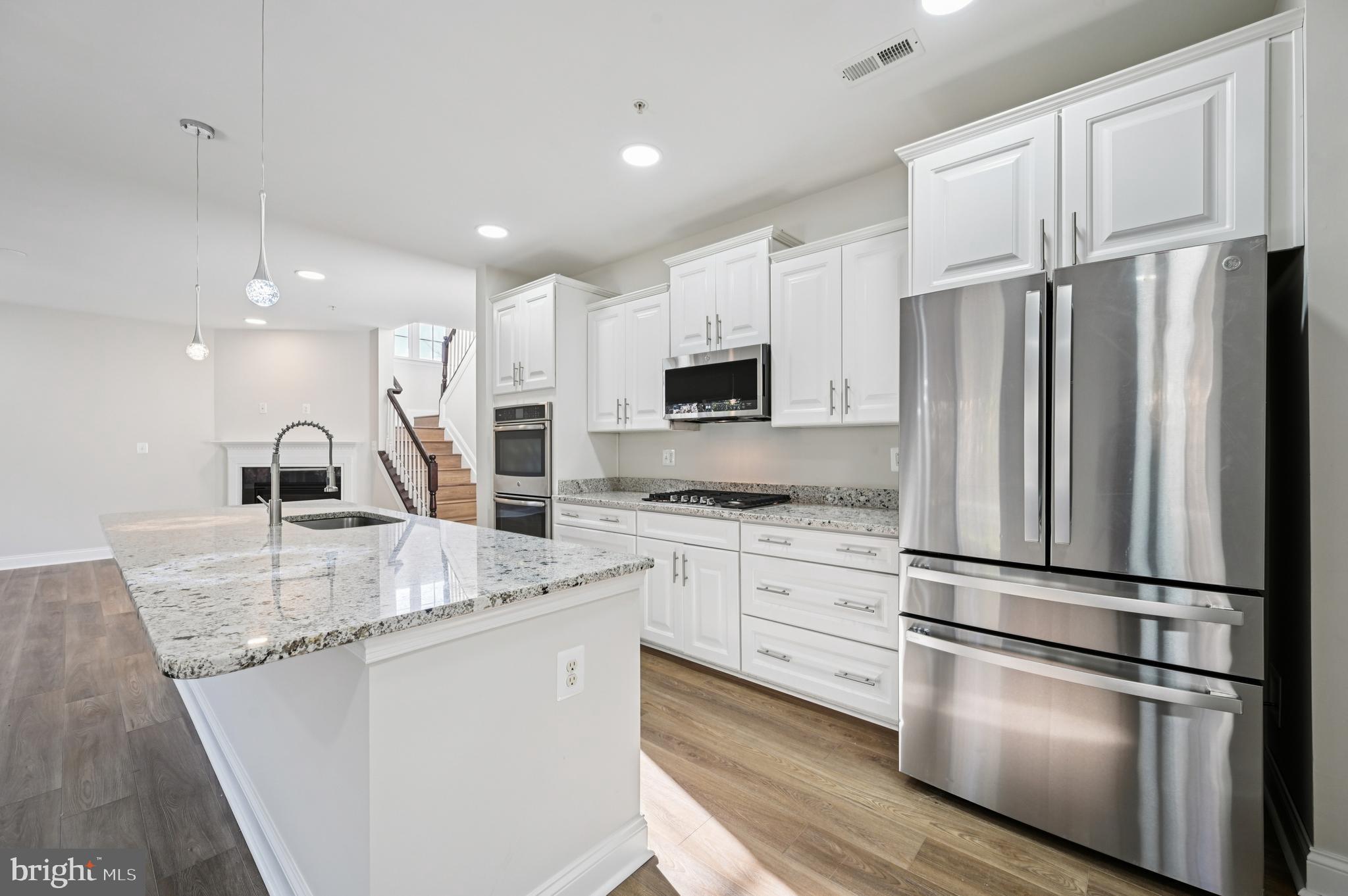 6305 Winters Lane Hanover, MD 21076 - Photo 2 of 3 a kitchen with kitchen island granite countertop appliances cabinets and a sink