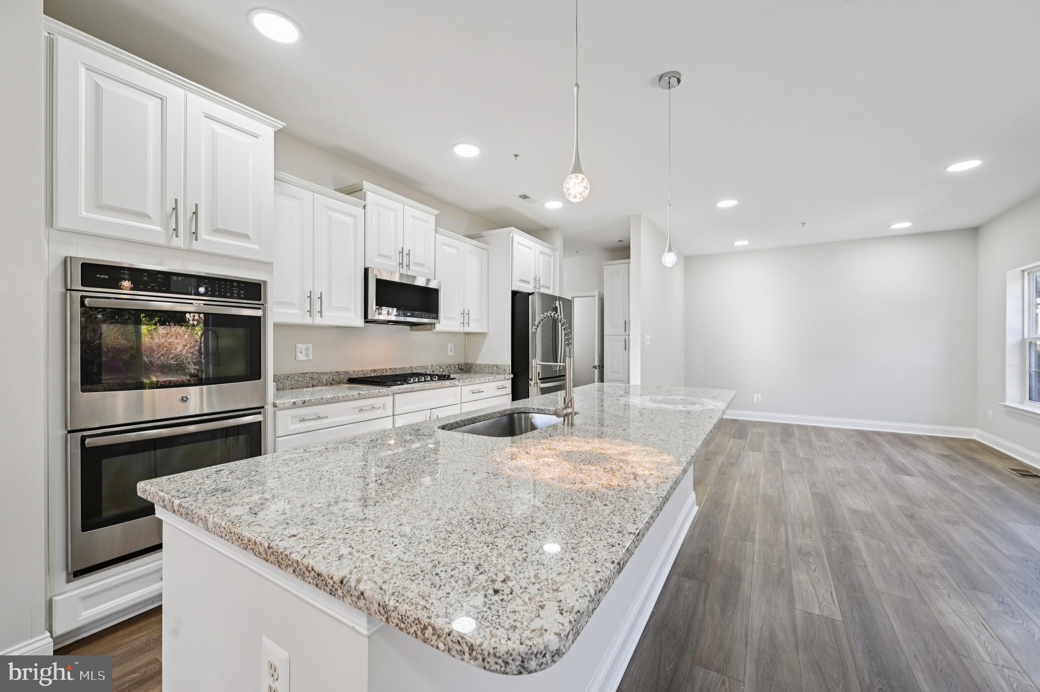 6305 Winters Lane Hanover, MD 21076 - Photo 31 of 83 a kitchen with kitchen island a counter top space appliances and cabinets