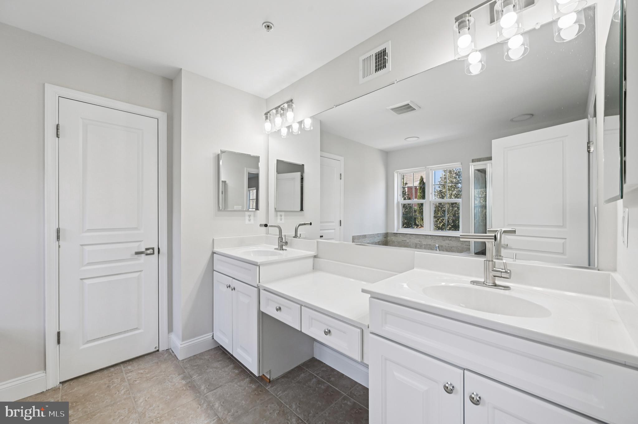 6305 Winters Lane Hanover, MD 21076 - Photo 50 of 83 a bathroom with double vanity sinks a vanity a lamp and a mirror
