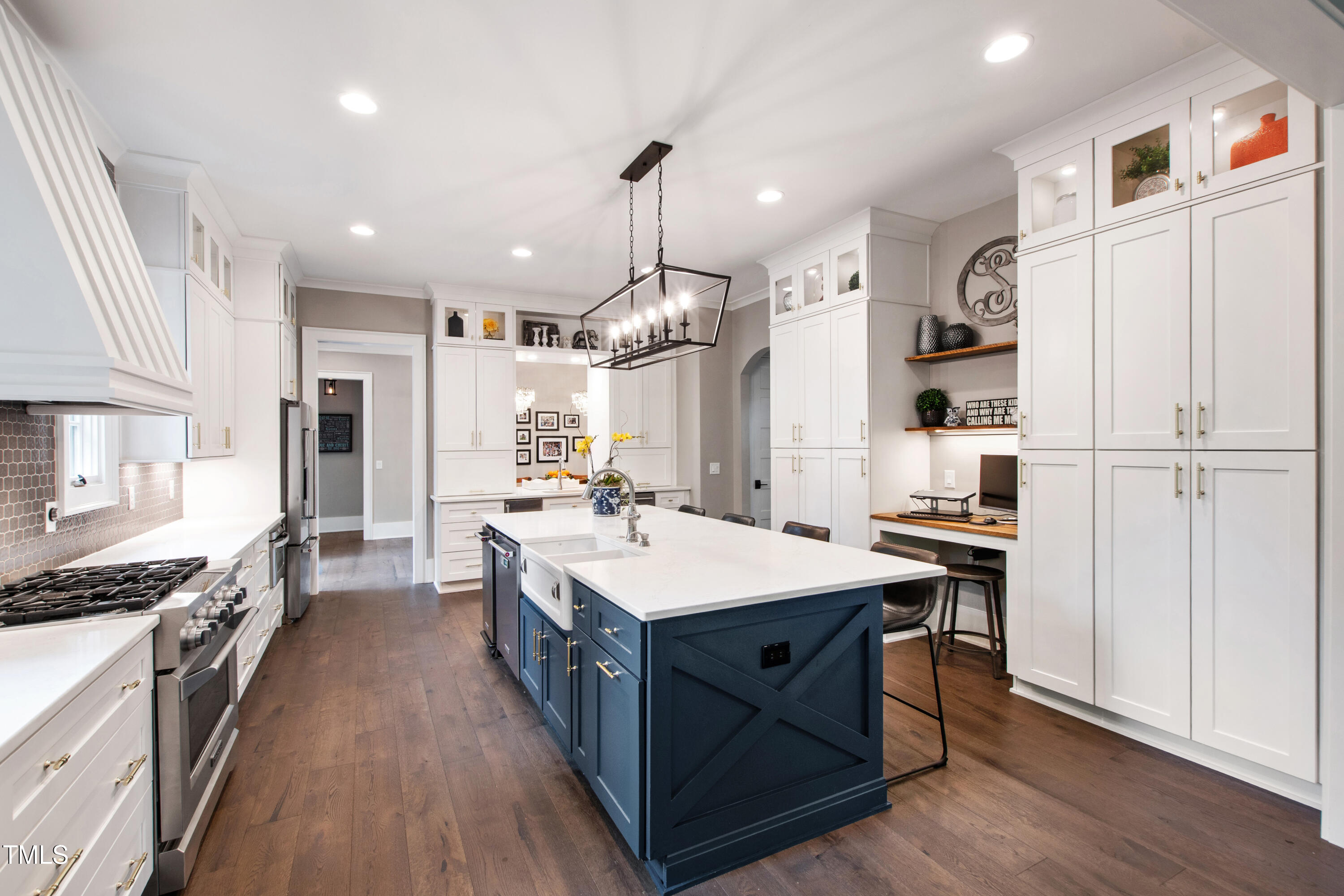 4237 Rowan Street Raleigh, NC 27609 - Photo 11 of 34 a large kitchen with stainless steel appliances a stove a sink dishwasher a refrigerator white cabinets and wooden floor
