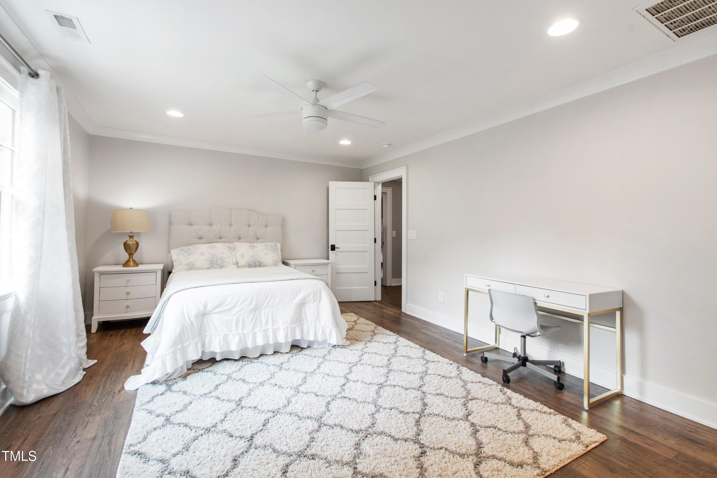 4237 Rowan Street Raleigh, NC 27609 - Photo 23 of 34 a bedroom with a large bed and a chandelier