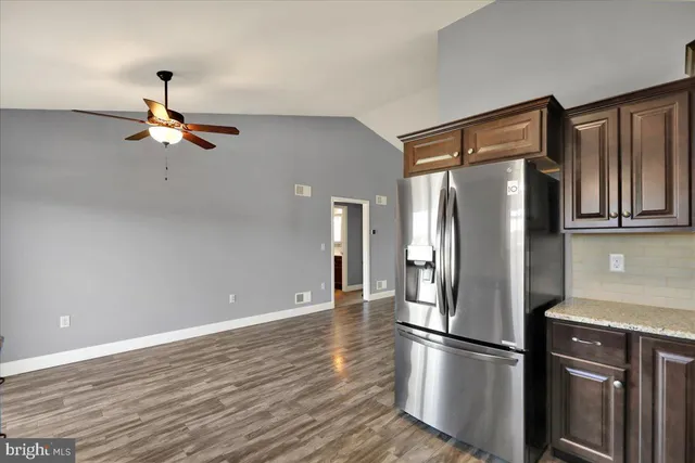 a kitchen with stainless steel appliances granite countertop a refrigerator a stove and a refrigerator