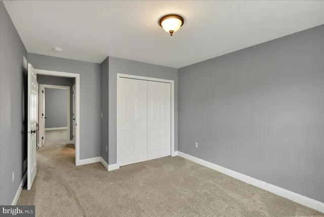 an empty room with closet area and glass door