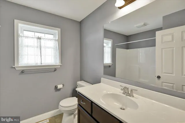 a bathroom with a sink toilet and mirror