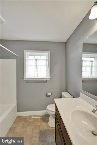 a bathroom with a sink a toilet and window