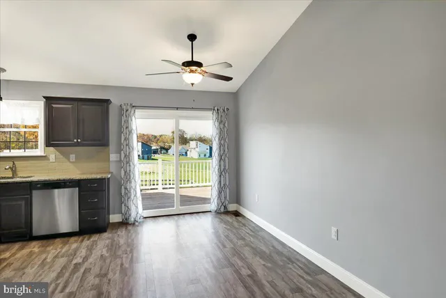 wooden floor in an empty room with a kitchen