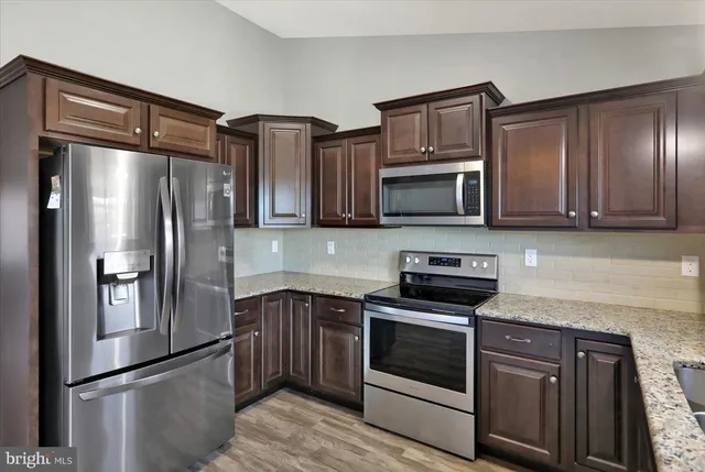 a kitchen with stainless steel appliances granite countertop a refrigerator stove and microwave