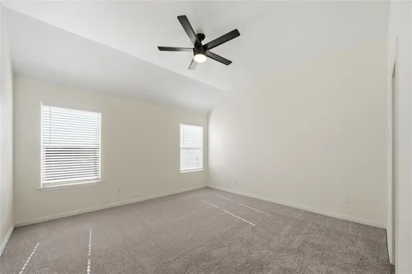 an empty room with a ceiling fan and window