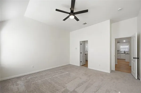 a view of a livingroom with a ceiling fan & entryway