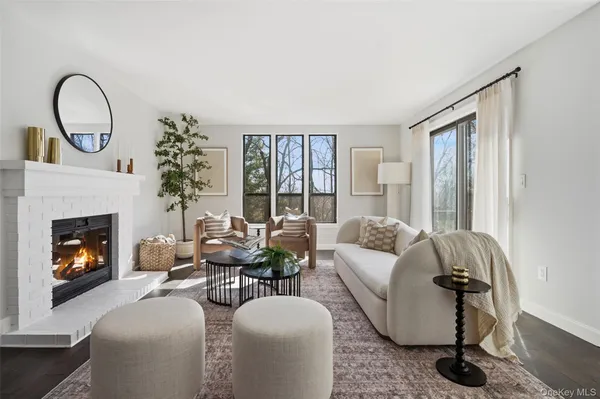 a living room with furniture a fireplace and a floor to ceiling window