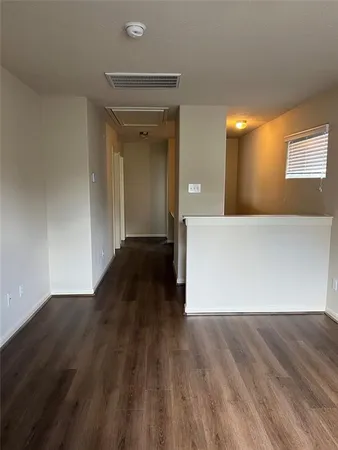 a view of a hallway with wooden floor and closet