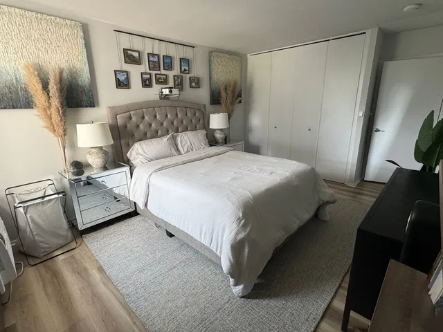 a bedroom with a bed closet and mirror