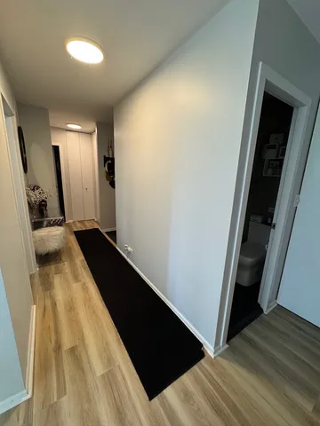 a view of a hallway with wooden floor and staircase