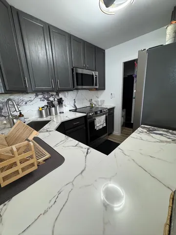 a kitchen with sink refrigerator and microwave
