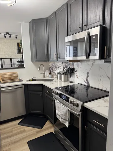 a kitchen with stainless steel appliances granite countertop a sink stove and microwave