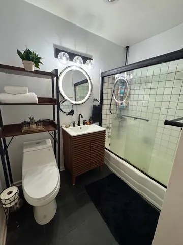 a bathroom with a toilet mirror vanity and toilet