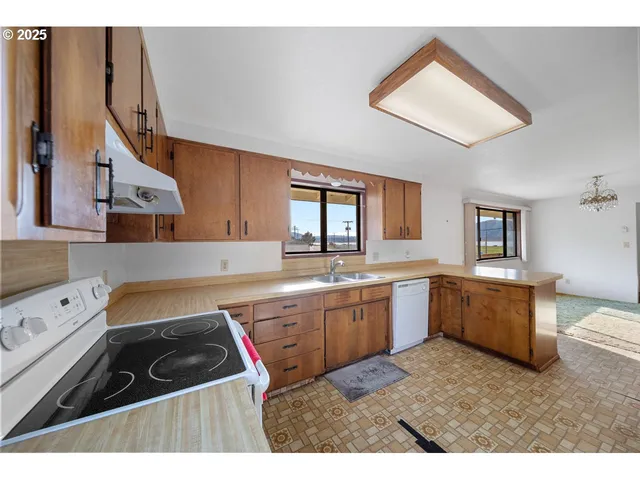 a kitchen with stainless steel appliances granite countertop a sink dishwasher stove and refrigerator with wooden floor