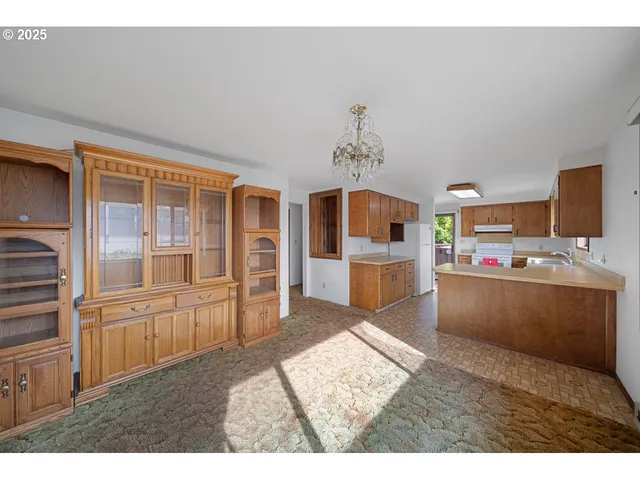 a view of empty room with kitchen