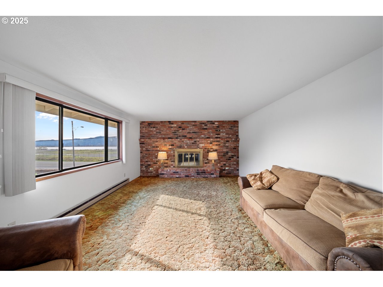 205 Marsh Street Gardiner, OR 97441 - Photo 27 of 46 a living room with furniture and a fireplace