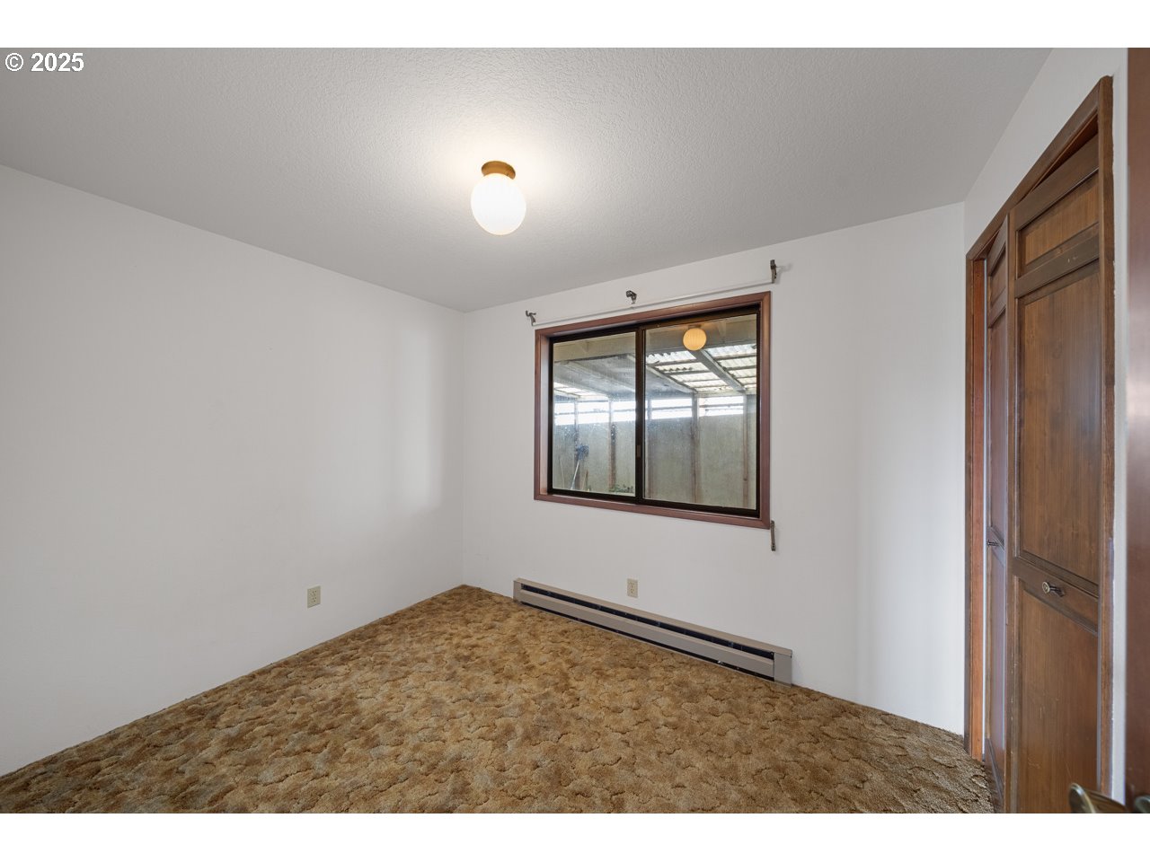 205 Marsh Street Gardiner, OR 97441 - Photo 35 of 46 a view of an empty room with wooden floor and a window