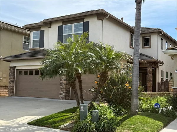 a front view of a house with a yard and potted plants
