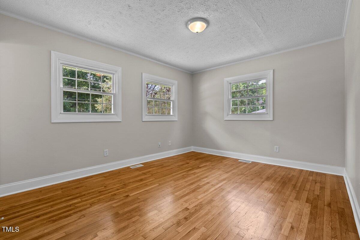 202 Purvis Street Garner, NC 27529 - Photo 12 of 28 a view of an empty room with wooden floor and a window