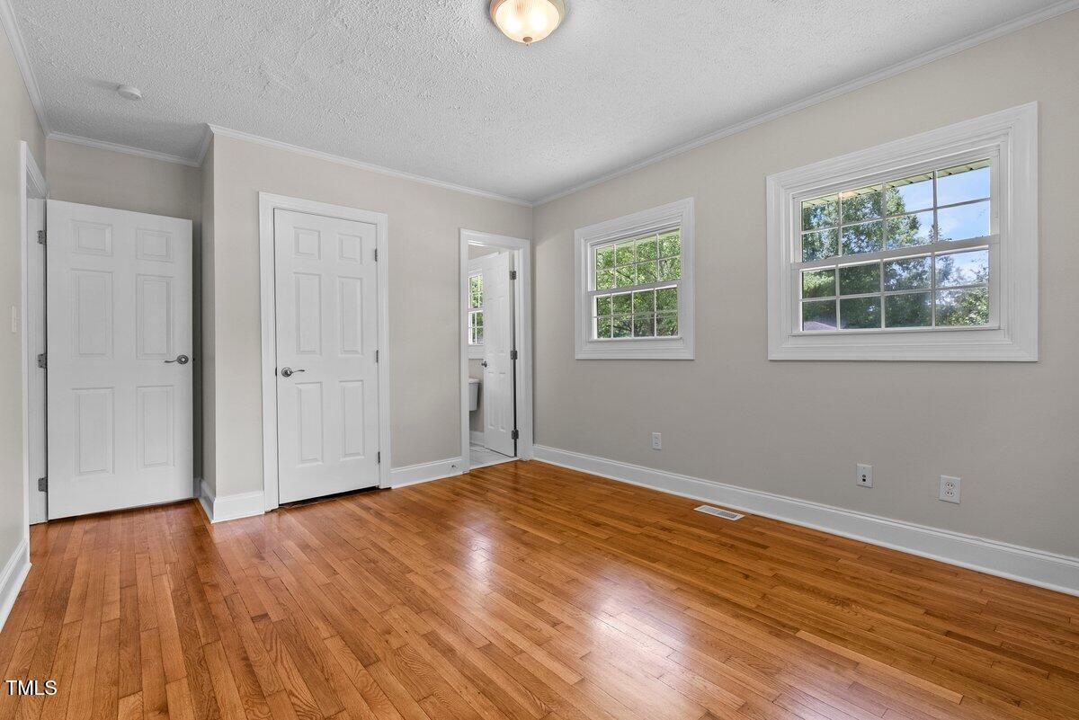 202 Purvis Street Garner, NC 27529 - Photo 13 of 28 a view of an empty room with wooden floor and a window