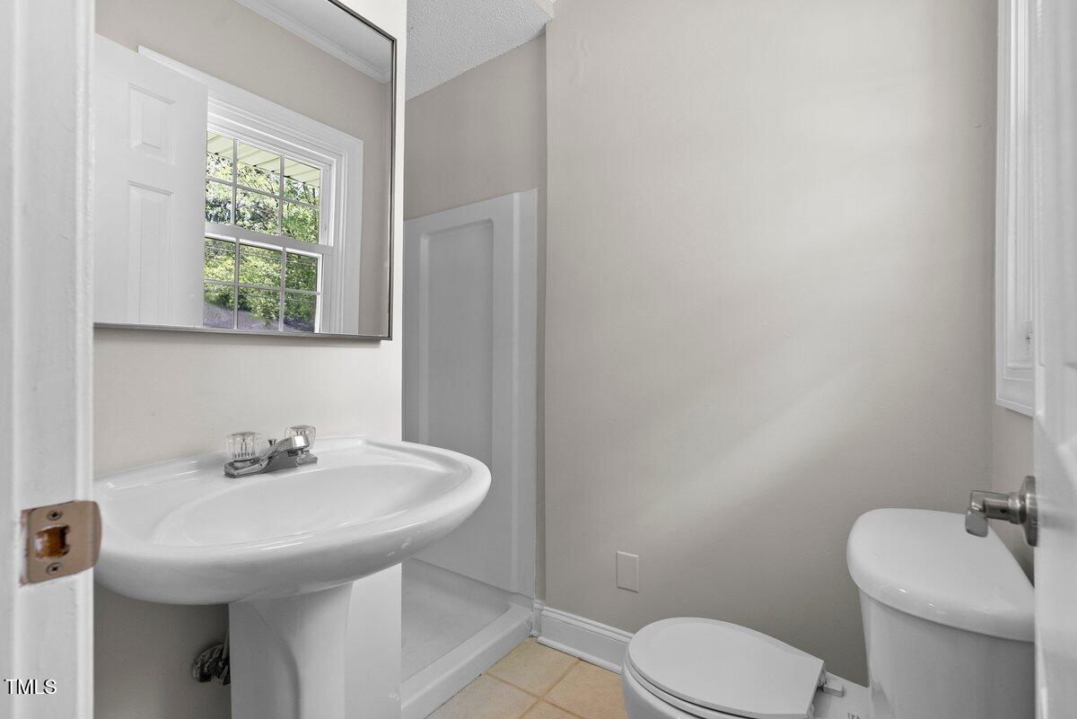 202 Purvis Street Garner, NC 27529 - Photo 14 of 28 a bathroom with a sink a toilet and a mirror