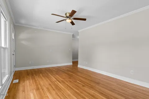 a view of empty room with wooden floor
