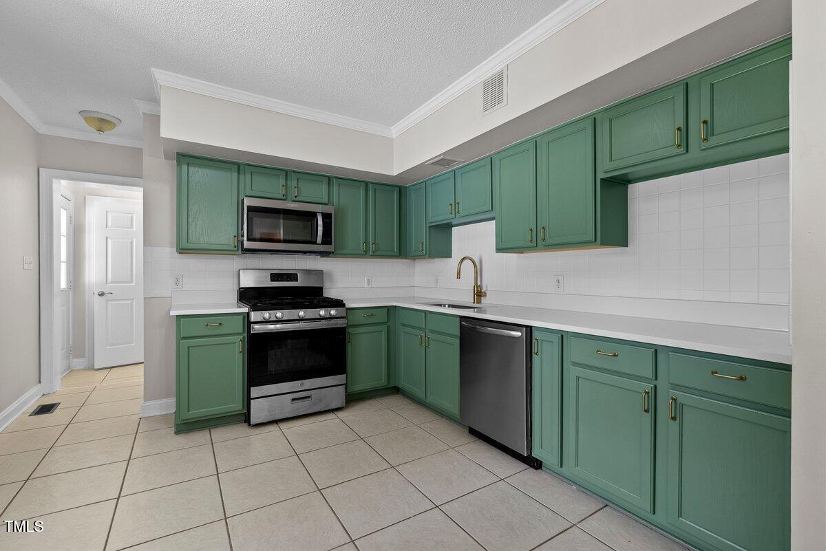 202 Purvis Street Garner, NC 27529 - Photo 8 of 28 a kitchen with a sink a stove and cabinets