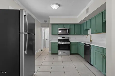 a kitchen with stainless steel appliances granite countertop a refrigerator and a stove top oven