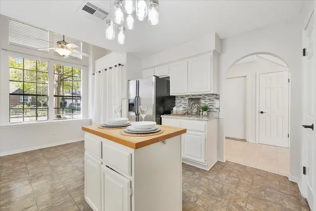 a kitchen with kitchen island white cabinets and stainless steel appliances
