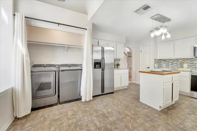 a kitchen with white cabinets and refrigerator