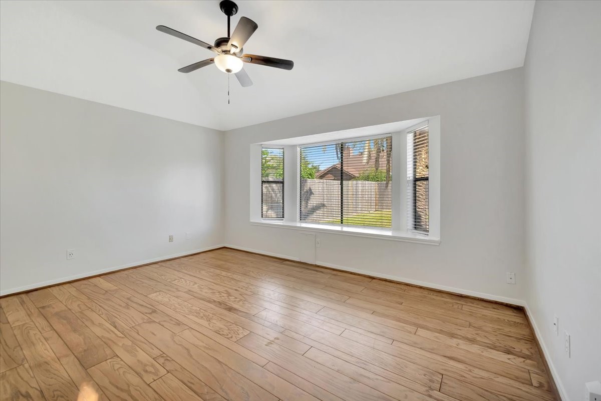 15131 Cranbourne Drive Houston, TX 77062 - Photo 17 of 42 a view of an empty room with window and wooden floor