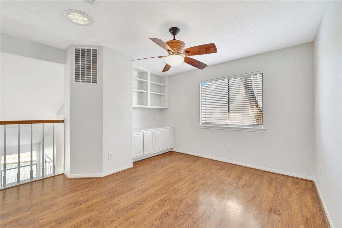 15131 Cranbourne Drive Houston, TX 77062 - Photo 24 of 42 a view of empty room with wooden floor and fan