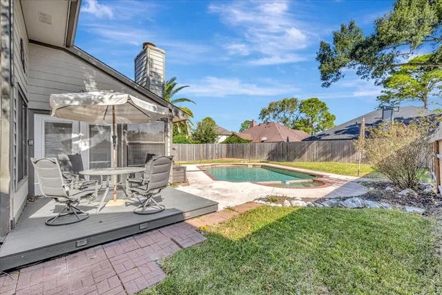 a view of a house with swimming pool and next to a yard