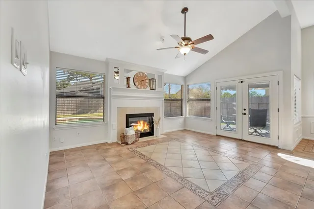 a view of an empty room with a fireplace and a chandelier fan