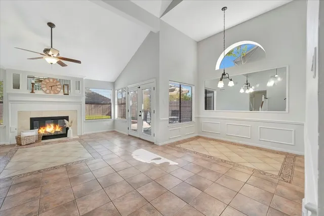 a view of an empty room with a fireplace and a chandelier fan