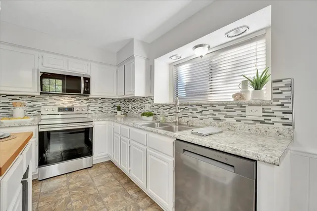 a kitchen with stainless steel appliances granite countertop a stove sink and microwave